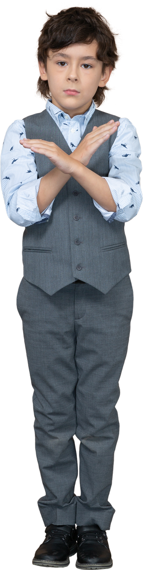 Vista frontal de un niño con traje gris que muestra un gesto de parada