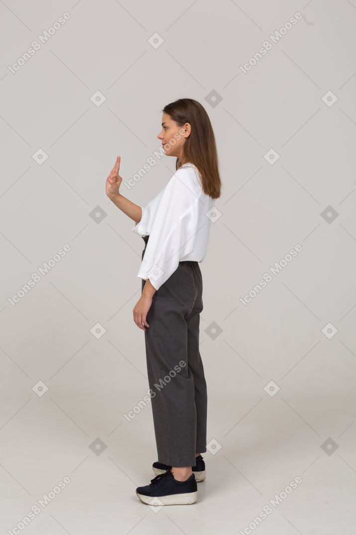 Side view of a young lady in office clothing showing ok gesture