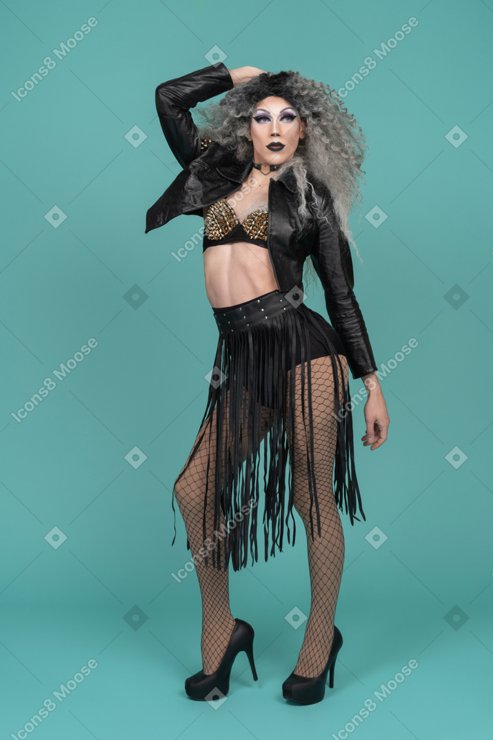 Drag queen in ganz schwarzem outfit posiert mit der hand hinter dem kopf