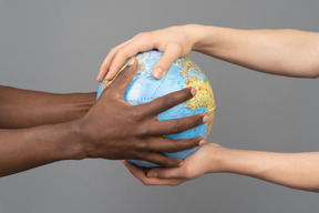 Mãos diferentes, segurando o globo da terra