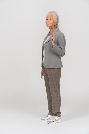Side view of an old lady in suit pointing with a finger