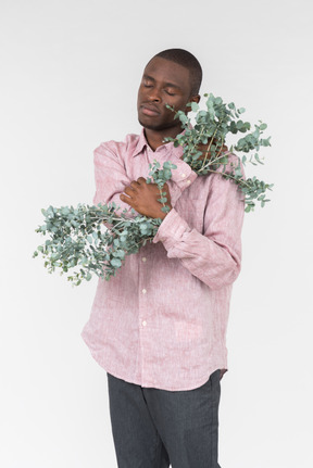 Good looking young man with a green branches