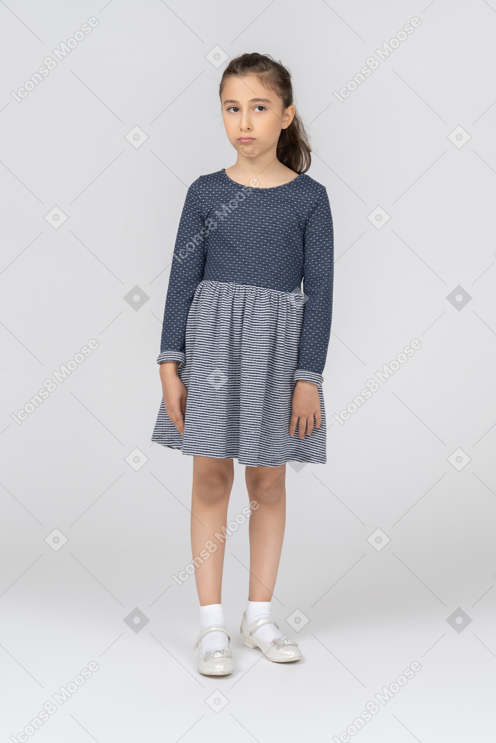 Vista frontal de una niña mirando hacia un lado con un puchero