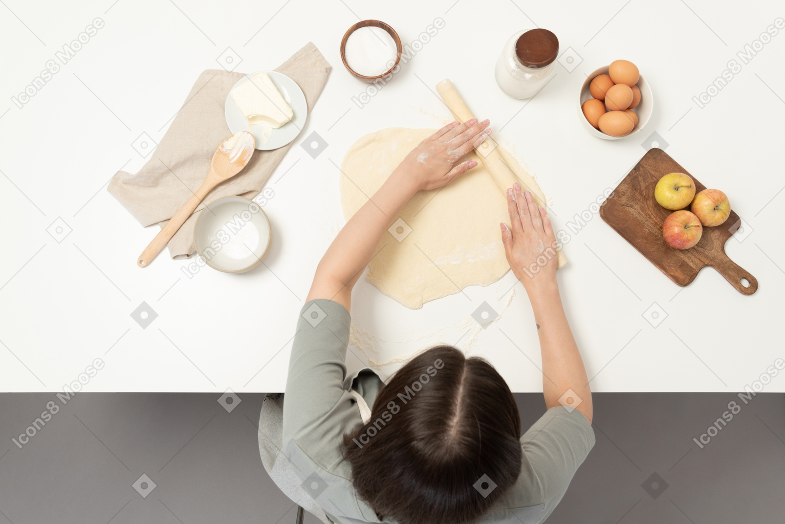 Eine bäckerin rollt keksteig aus