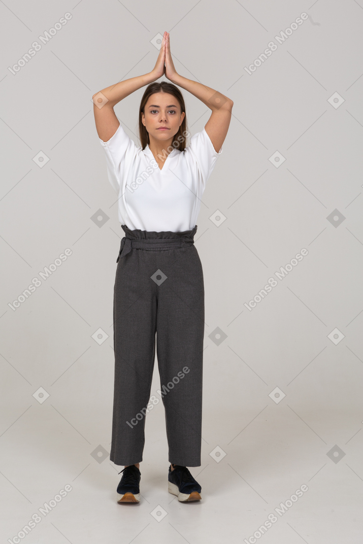 Vista frontal de uma jovem com roupa de escritório, segurando as mãos na cabeça
