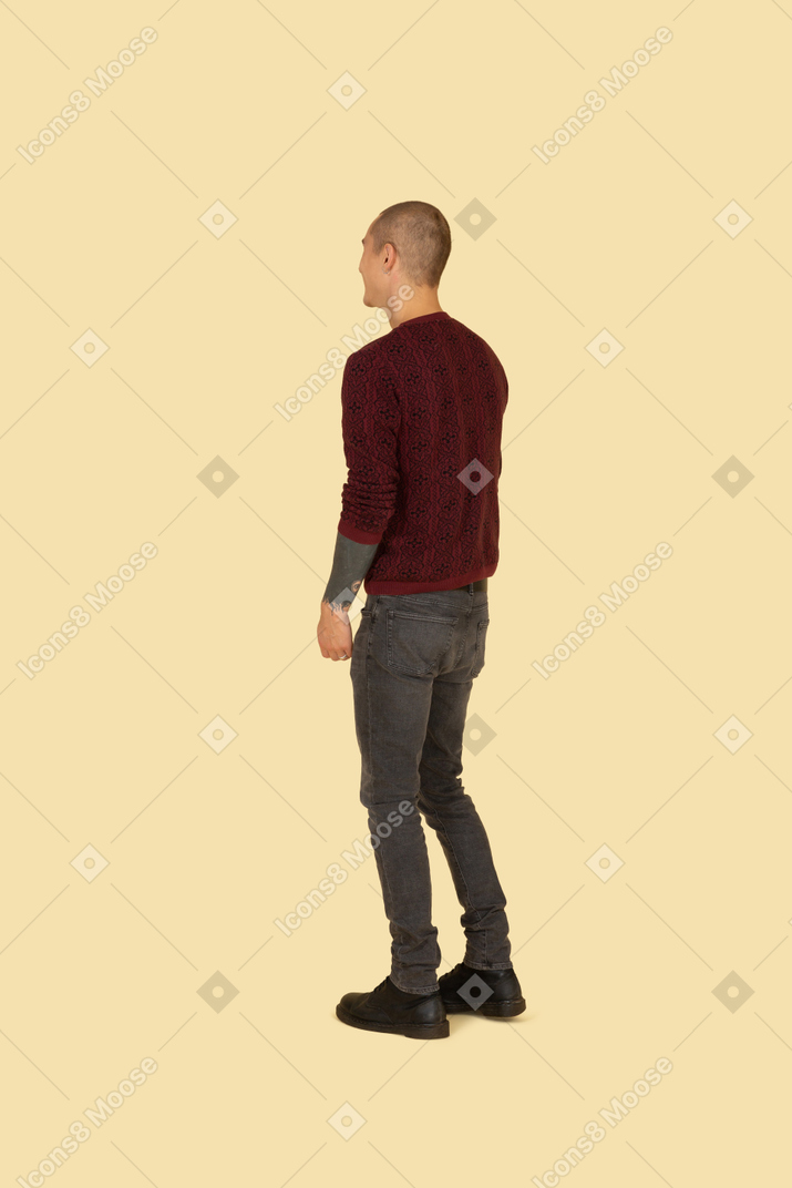 カジュアルな服を着て笑っている若い男性の背面図