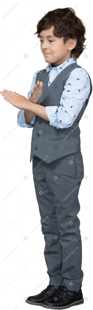 Side view of a boy in suit showing stop gesture