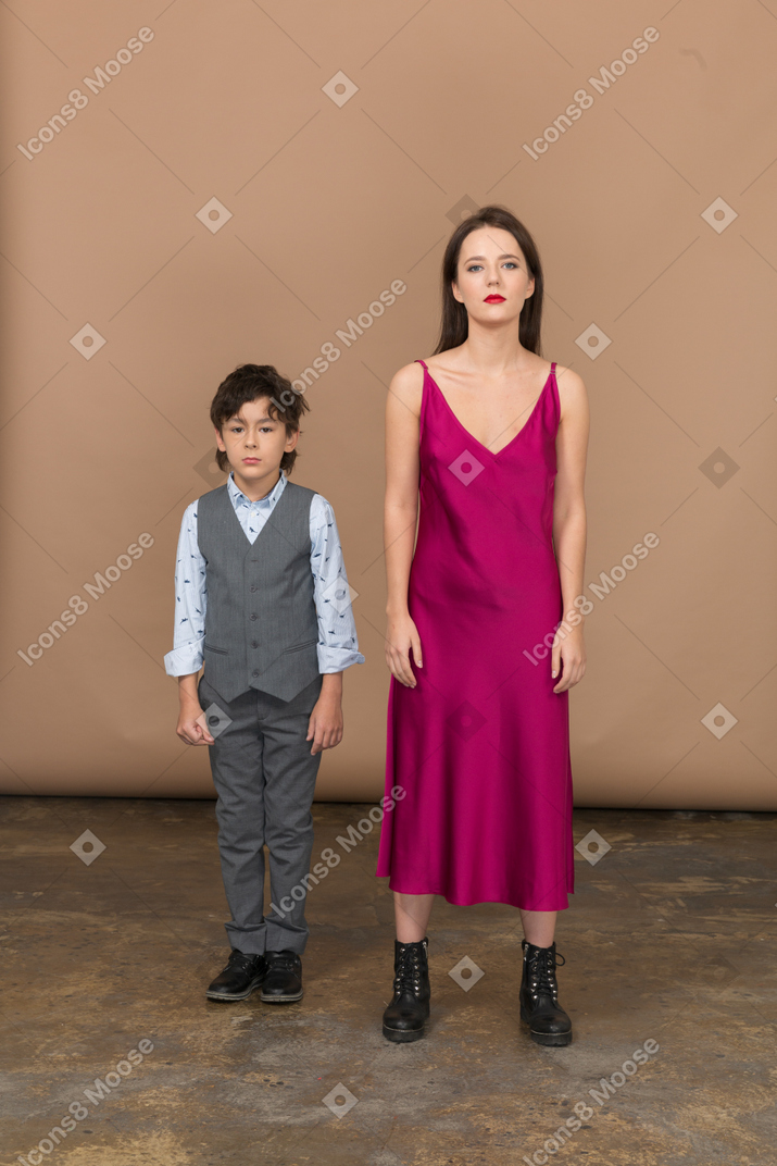 Vista frontal de um menino de colete e uma jovem