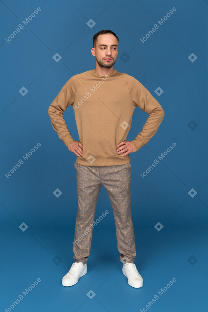 Young man standing with hands akimbo