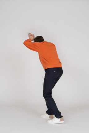 Young man in orange sweatshirt jumping