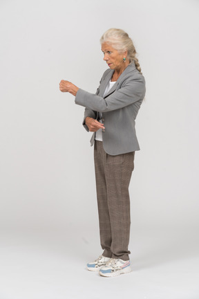 Side view of a serious old lady in suit explaining something