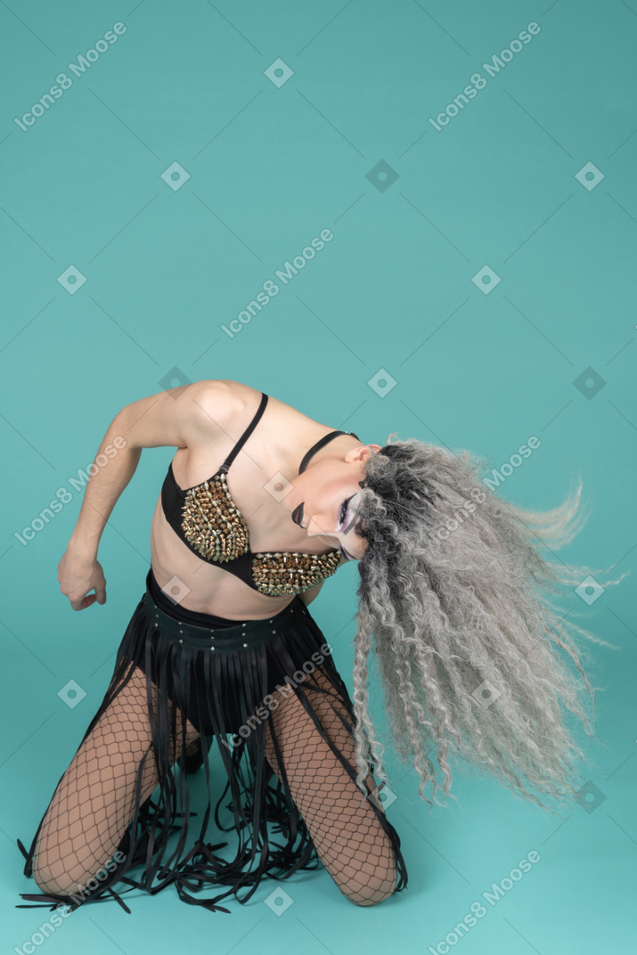 Drag queen standing on knees and shaking their hair