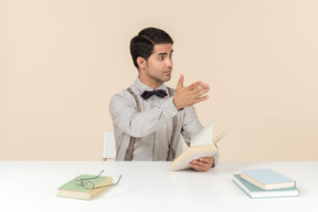 Joven profesor explicando algo y señalando con una mano