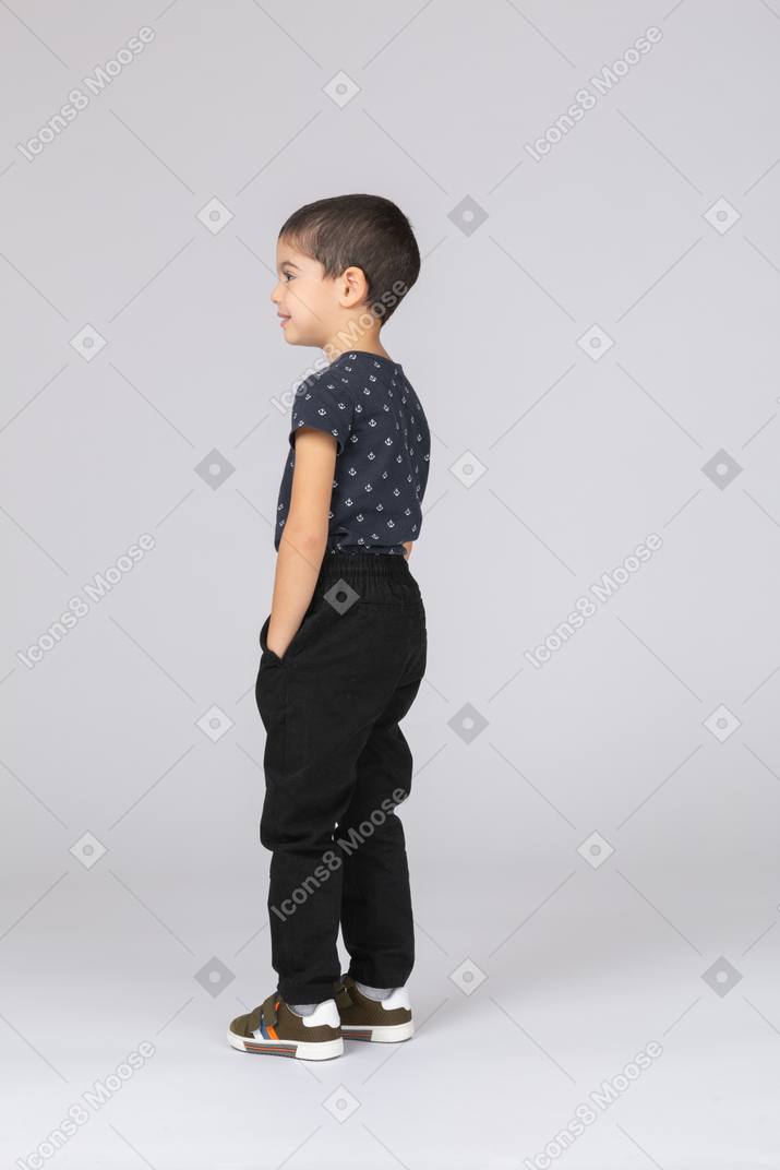 一个穿着休闲服的男孩双手插口袋站立的侧视图