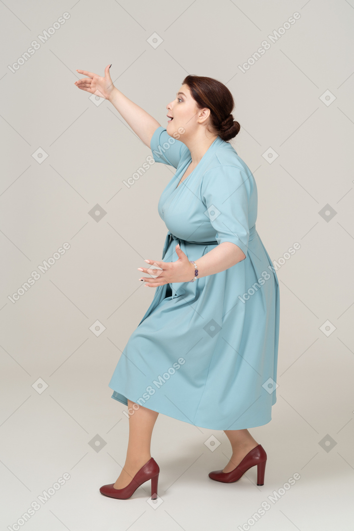 Side view of a woman in blue dress showing the size of something