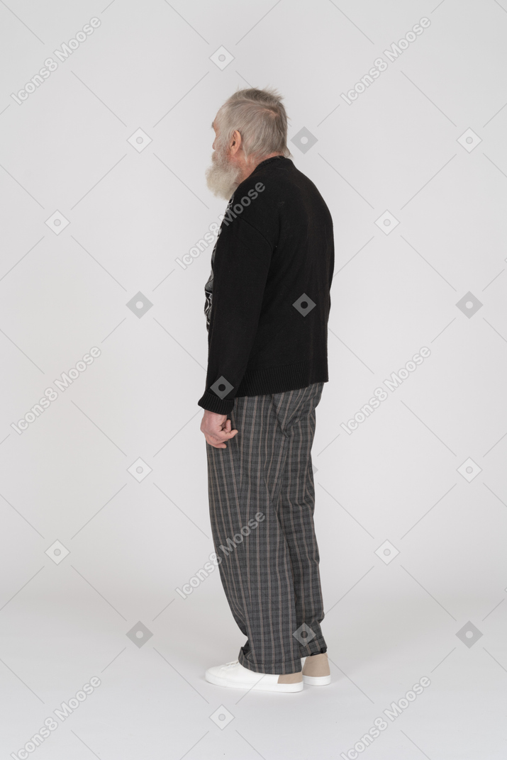 一位身穿黑色毛衣的老人站立的侧视图