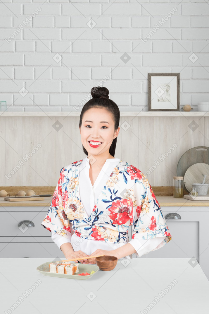 A woman in a kimono holding a plate of food