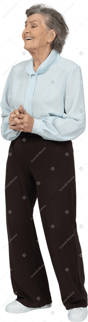 Vue de face d'une vieille femme heureuse en chemisier et pantalon main dans la main