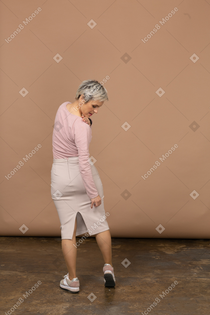 一个穿着休闲服的女人看着她的腿的后视图