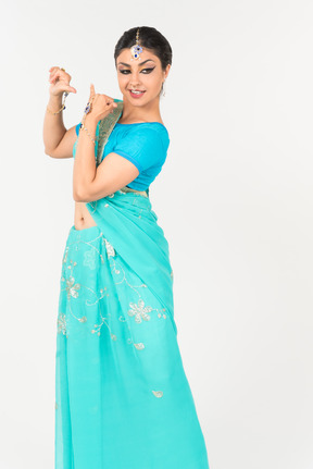 Young indian woman in blue sari standing in dance position