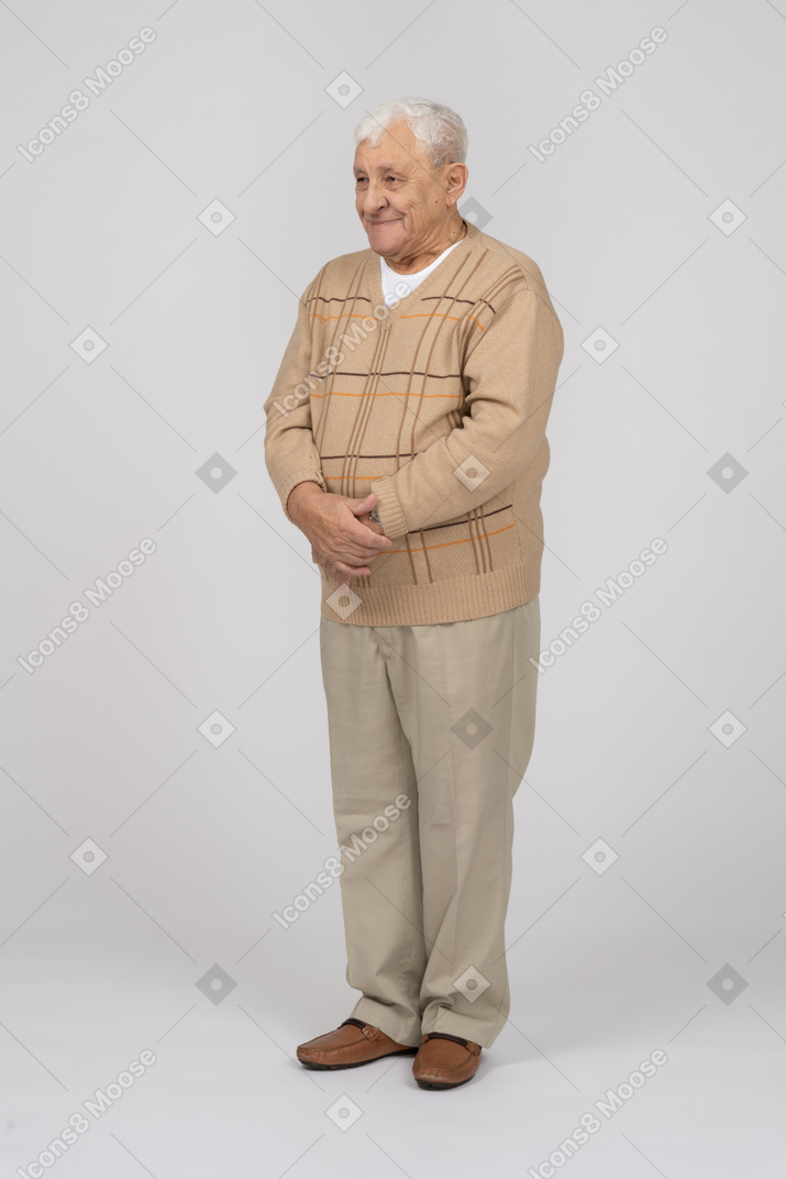 Vorderansicht eines glücklichen alten mannes in freizeitkleidung, der still steht
