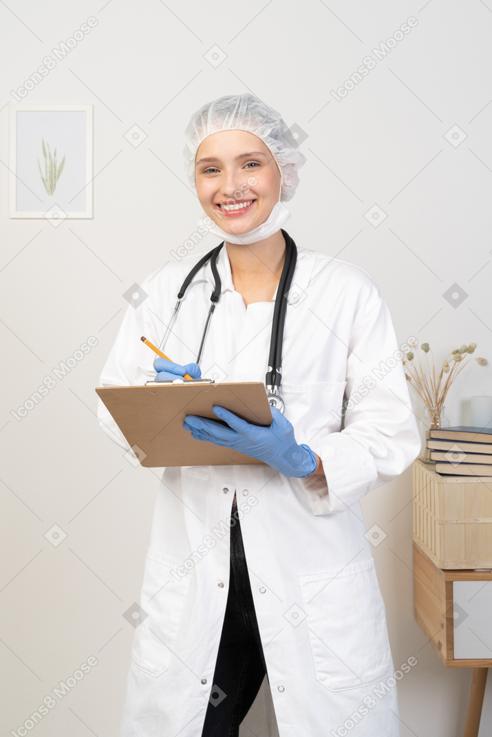 彼女のタブレットにメモをとっている若い女性医師の正面図