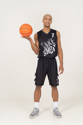 Front view of a young male basketball player holding a ball