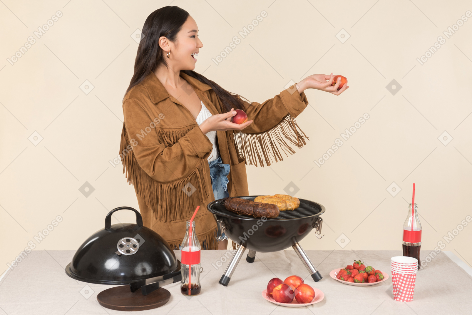 Young asian woman holding fruits and standing near grill