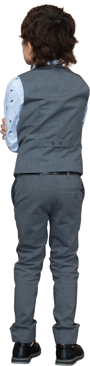 Rear view of a boy in suit standing with crossed arms