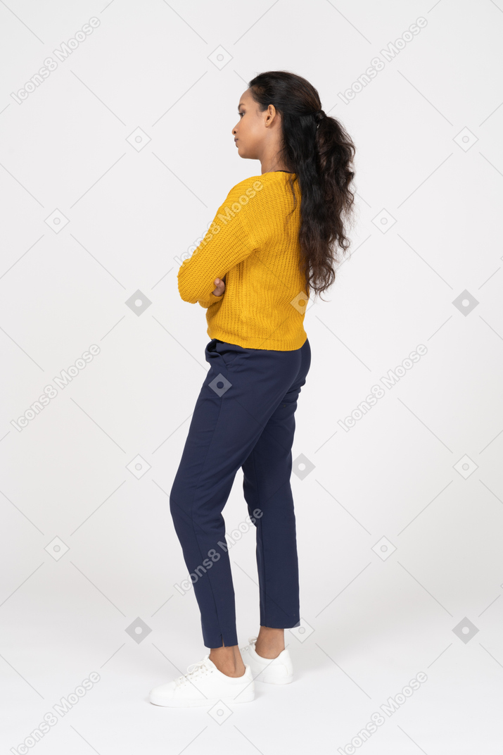 一个穿着休闲服的女孩交叉双臂摆姿势的侧视图