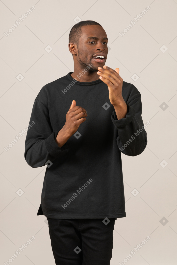 Мужчина в черной одежде трогает подбородок