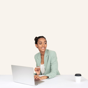 A woman sitting at a table with a laptop