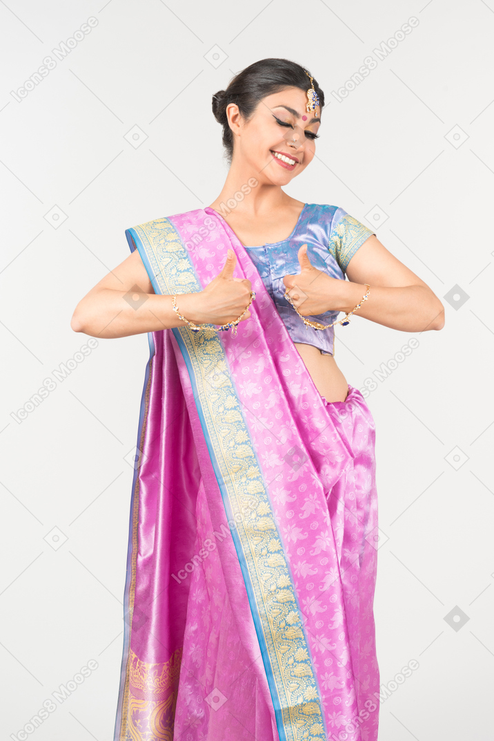 Young indian woman in purple sari showing thumbs up