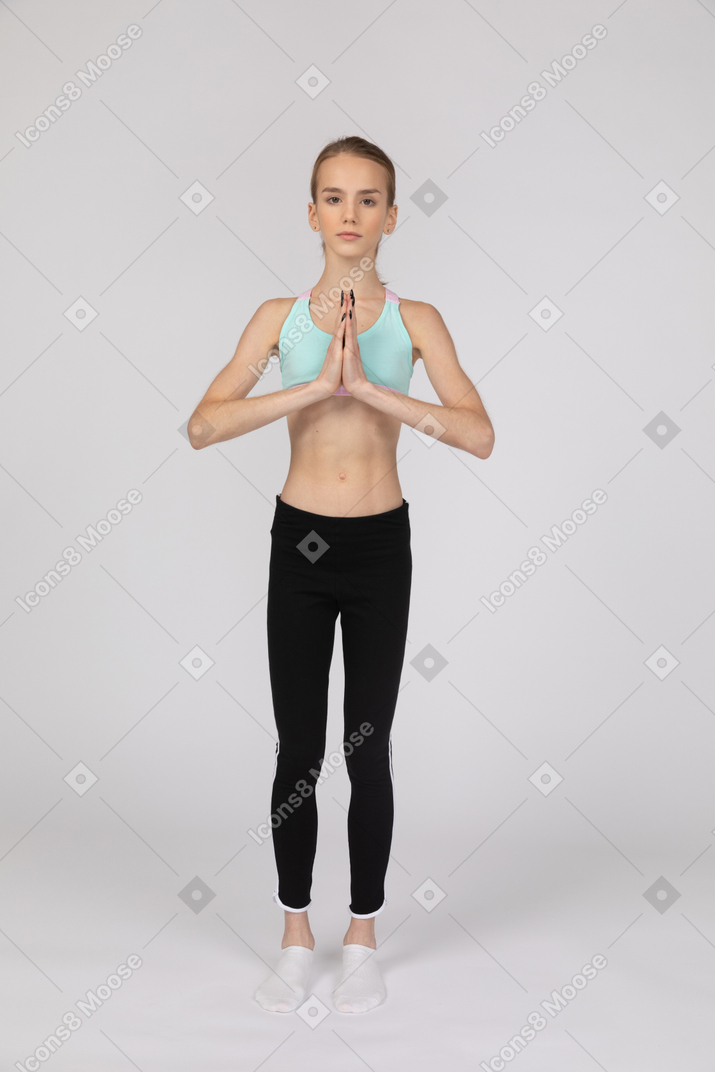 Teen girl standing with her hands folded