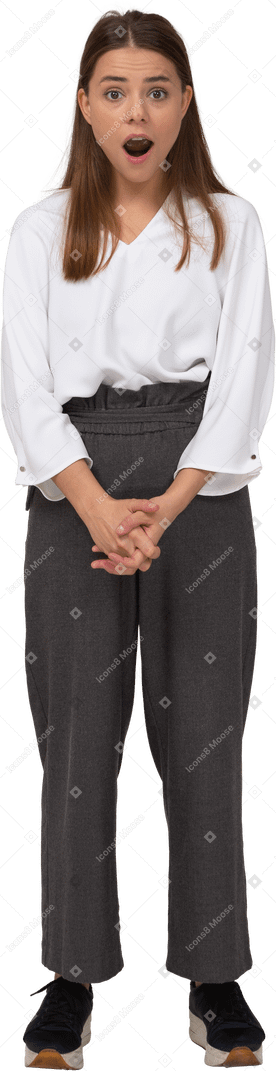 Front view of a shocked young lady in office clothing holding hands together