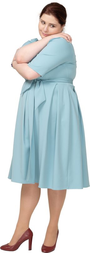 自分を抱き締める青いドレスを着た女性の正面図