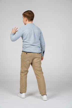 Vista traseira de um menino mostrando o tamanho pequeno de algo