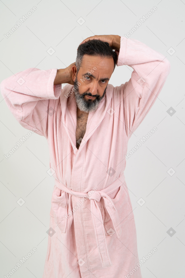 Mature man in pink robe adjusting his hair