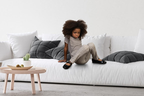 A little girl sitting on a white couch