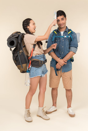 Screaming young woman beating his man with travel map