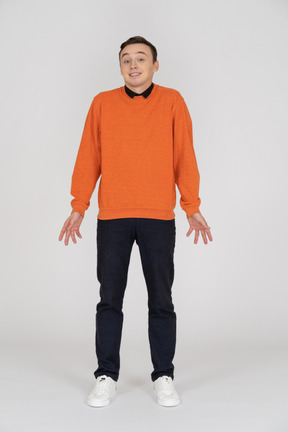 Junger mann im orangefarbenen sweatshirt stehend