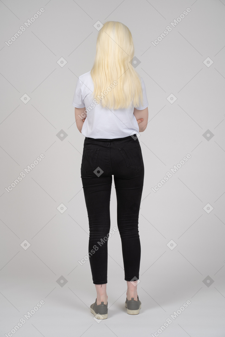 Vista posteriore di una giovane donna con le braccia conserte