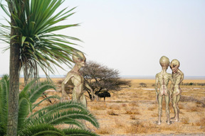 A group of aliens standing in the middle of a desert