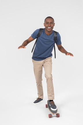 Black male tourist standing on skateboard