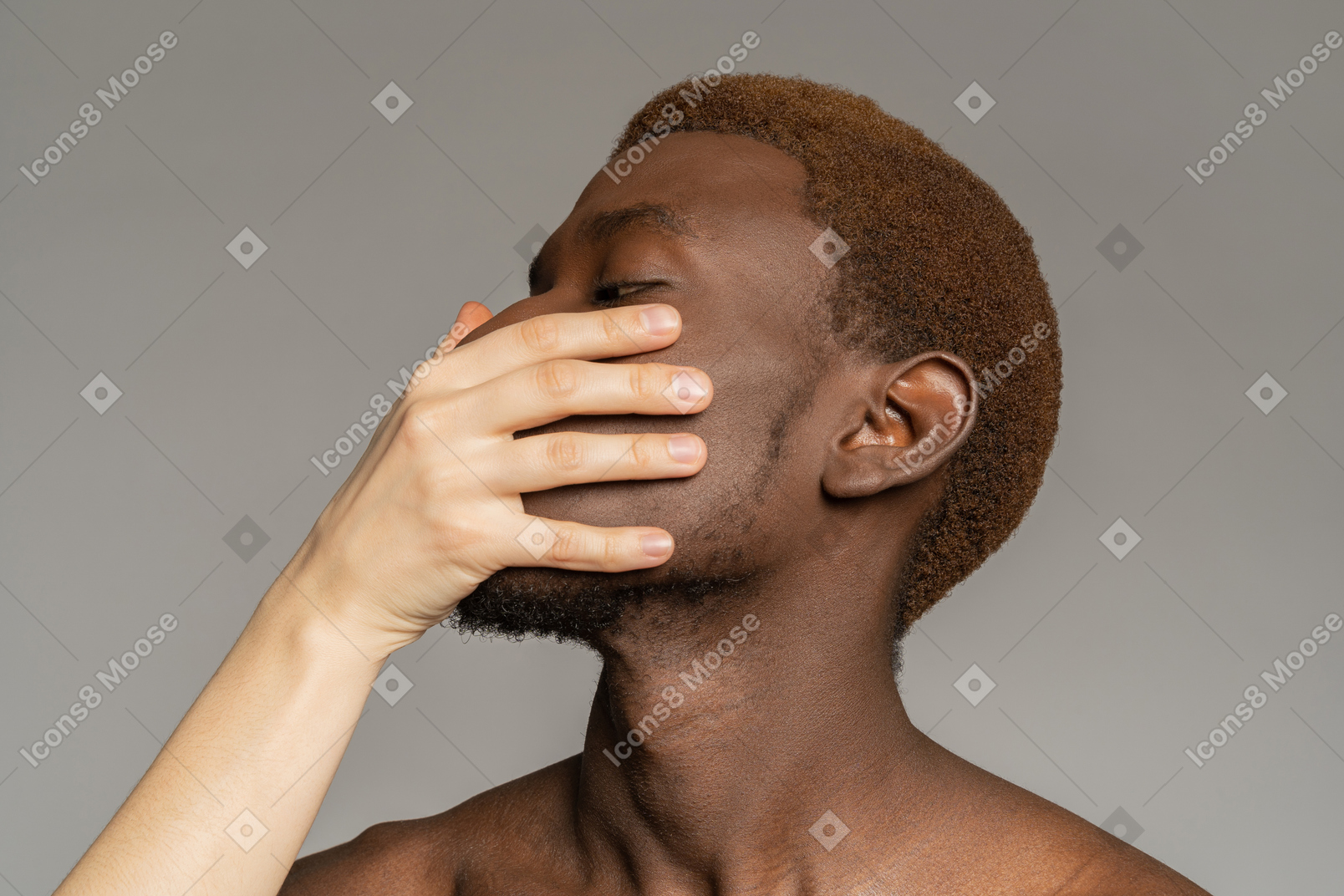 White hand touching the face of black young man
