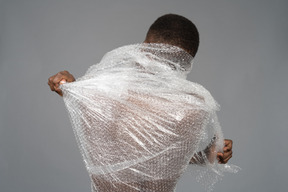 Pack view of an african male tearing up the plastic wrap