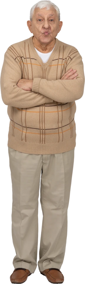 Front view of an old man in casual clothes standing with crossed arms and looking at camera