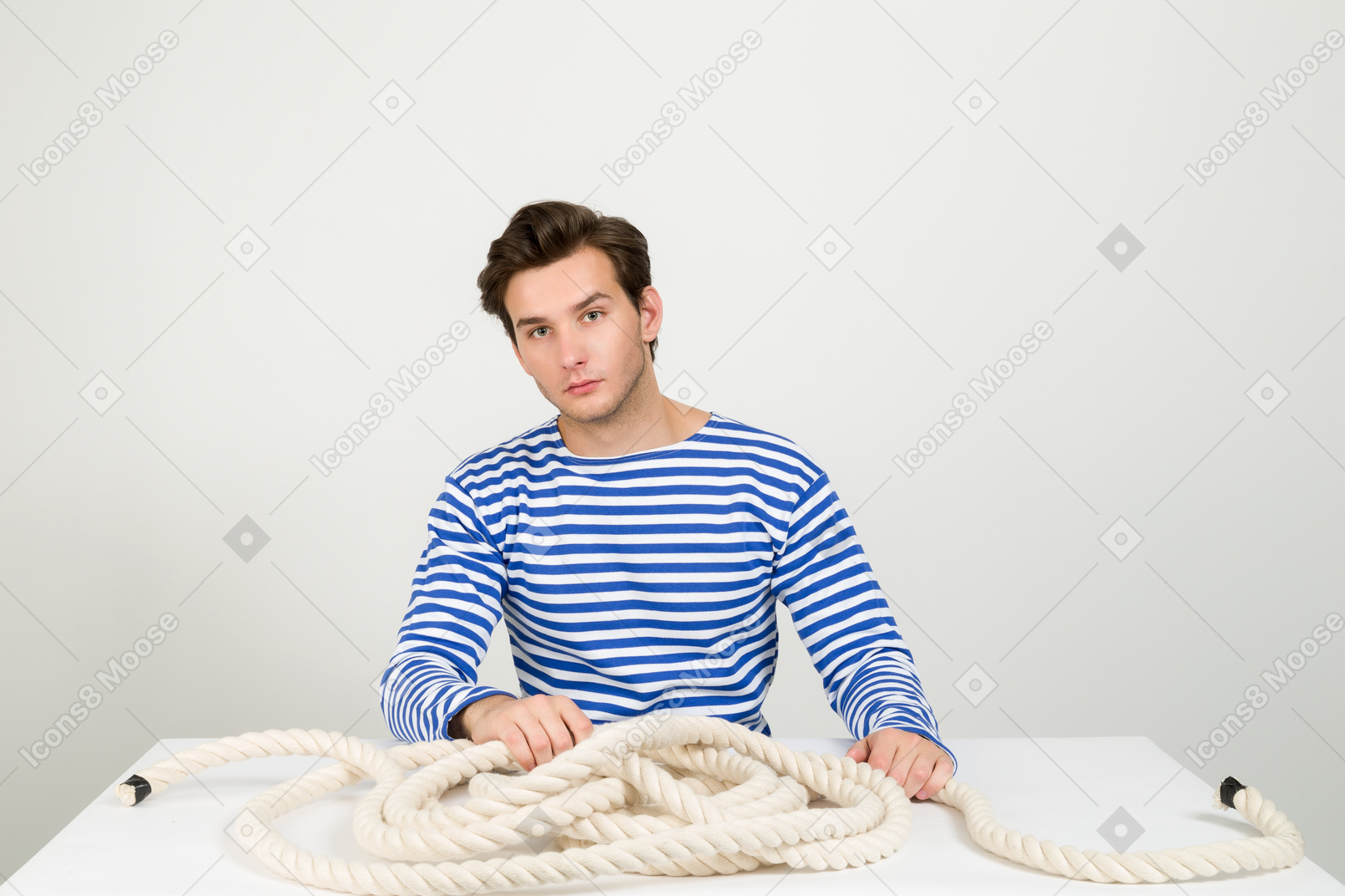 Marinheiro sentado à mesa com corda nele