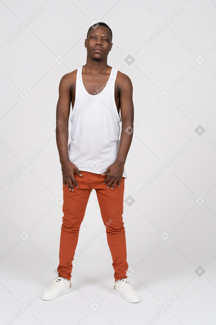 Man in tank top with one eye closed