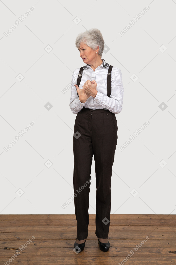 Vorderansicht einer weinenden alten dame in der bürokleidung, die hände zusammenhält